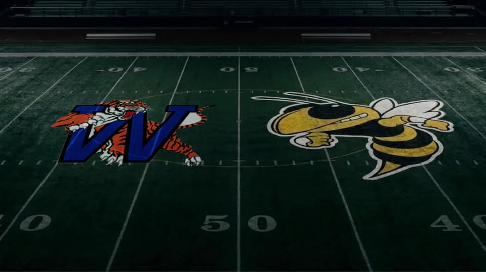 The Waverly Central Tigers and Fairview Yellow Jackets logos painted at midfield on a football field.